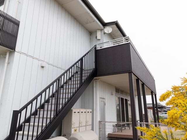 白い建物と階段外観 外観 清潔感のある白い壁の建物です。階段はしっかりと手すりが設置されており、安全に配慮された設計になっています。