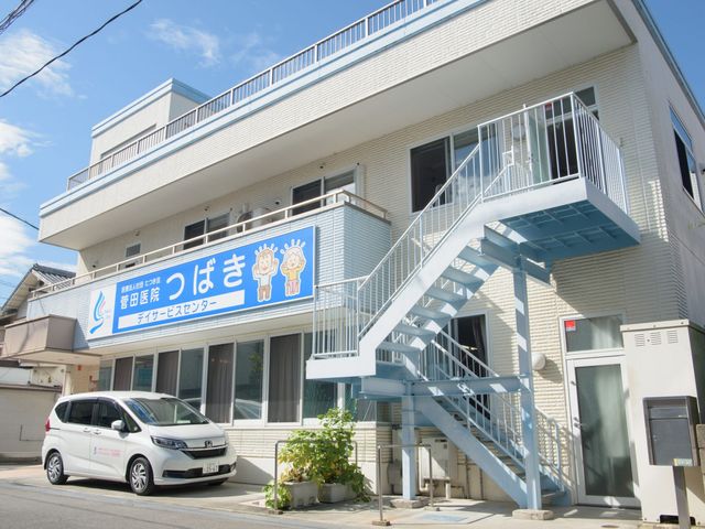看板と建物の外観 外観 清潔感のある建物が日光を浴びています。志を持つ職場で、看板には親しみやすいデザインが見られます。
