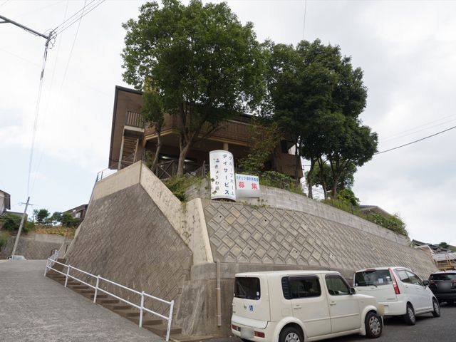 施設外観の全景 外観 緑豊かな丘の上にそびえ建つ、開放感のある明るい施設です。訪れる方々に安らぎと活力を提供する場所となっております。