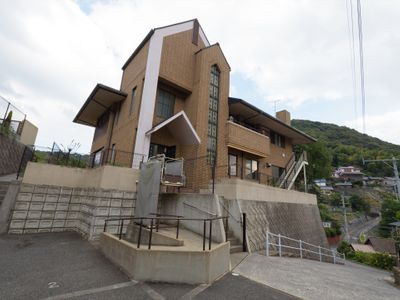 斜面に建つ明るい外観