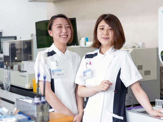 笑顔のスタッフが並ぶ実験室  