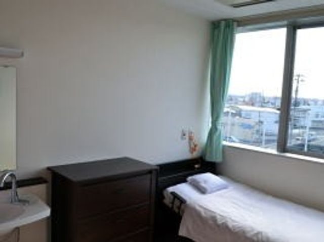 窓辺の居室 居室   大きな窓から光が入る、明るい居室です。シンプルな家具配置で、落ち着いて過ごしやすそうです。