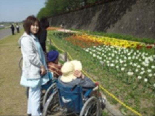 花壇とお年寄りと介助者