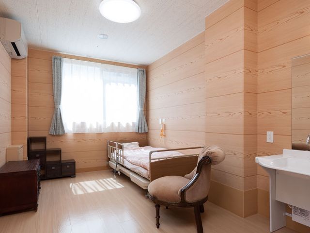 木製の壁が特徴の居室 居室 温かみのある木製の壁で囲まれた居室で、明るい自然光が柔らかに差し込んでいます。快適な空間でゆったりと過ごせます。