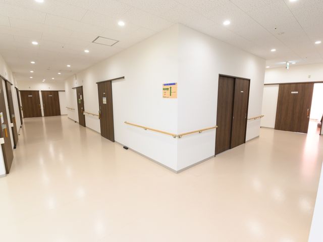 清潔感ある廊下 共用廊下 手すり沿いに広がる足元明るい廊下が、のびやかな移動空間を提供しています。安全と快適性を重視した造りです。