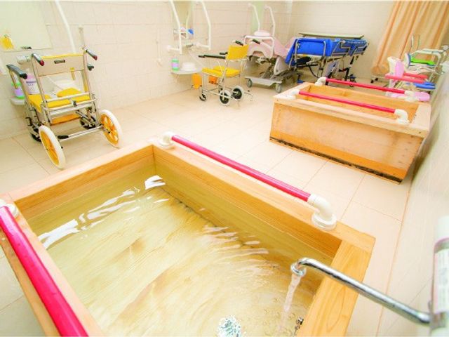 木製浴槽が並ぶ浴室 浴室   木製の浴槽が並ぶ、明るく清潔感のある浴室です。車椅子でも使いやすそうな備えも見え、入浴介助の場面を想像しやすいです。