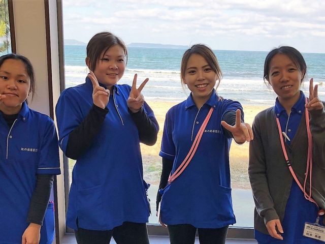 スタッフと海の景色 スタッフイメージ 笑顔あふれるスタッフがいる明るい空間。窓からは海が望め、開放感溢れる雰囲気です。