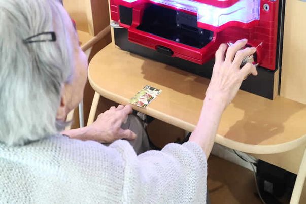 高齢者が自動販売機を操作
