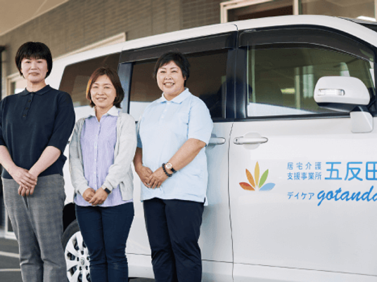 送迎車前の職員  