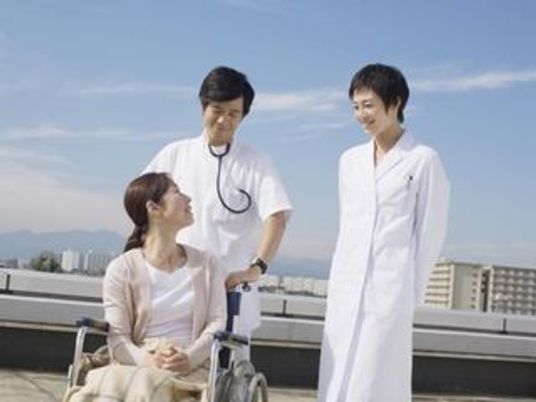 屋上で笑顔の職員と利用者