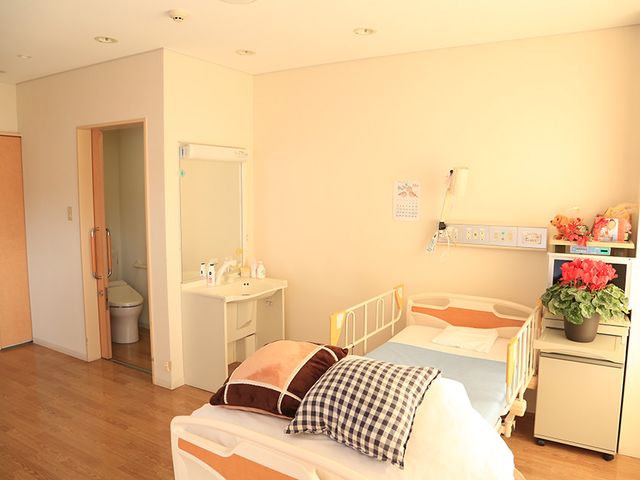 ベッドと洗面台の居室 居室 広々とした明るい居室では、自然光が差し込み、快適な休息が可能です。洗面台も完備しています。