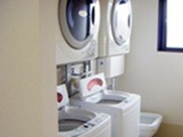 洗濯機が並ぶ部屋 コインランドリー 清潔で機能的なランドリールームです。付帯設備で日々の洗濯も安心して行えます。
