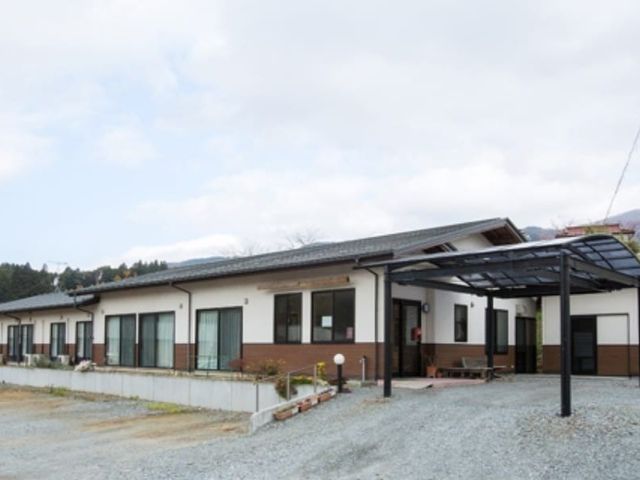 平屋の施設外観 外観   平屋づくりの建物で、玄関前には屋根付きのスペースがあります。広めの敷地があり、落ち着いた雰囲気です。