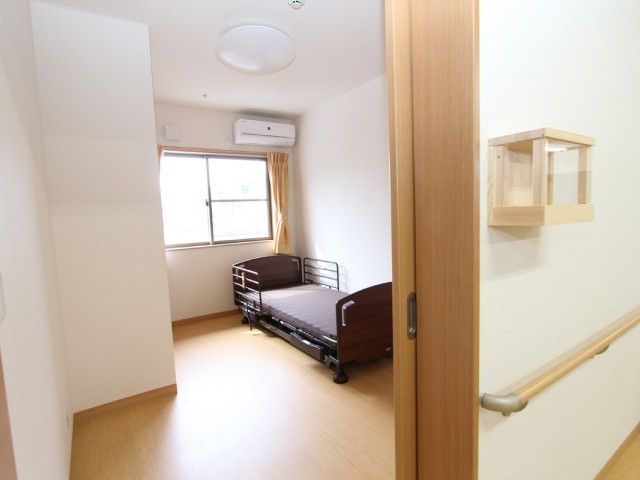 居室の明るい空間 居室 広々とした個室は窓から自然光が差し込み、落ち着いた雰囲気で過ごせるデザインです。ベッドの設備も整っており、快適にお過ごしいただけます。