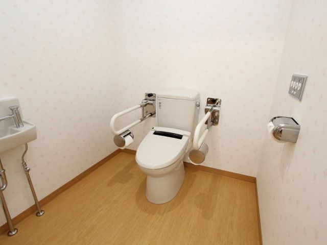 手すり付きのトイレ トイレ 安心してご利用いただける手すり付きの清潔なトイレ空間です。周囲の手摺りはサポートを提供します。