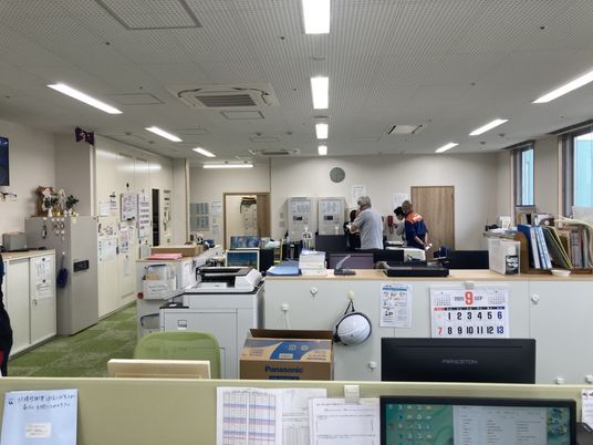 スタッフがいる明るい事務室  