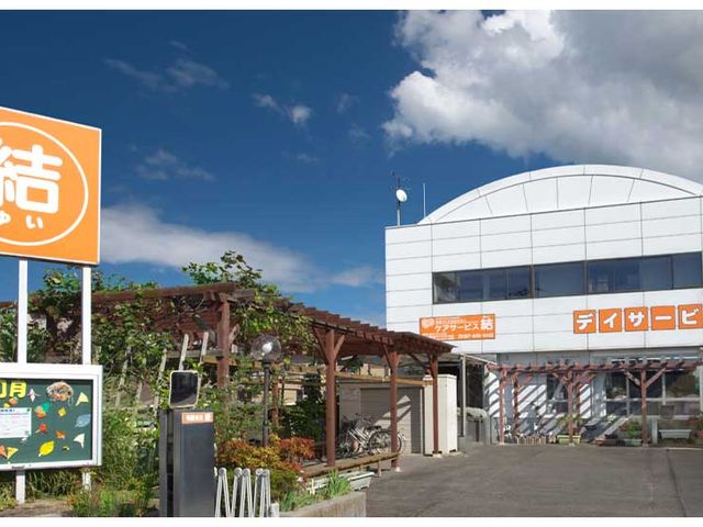 看板と建物入口 外観 青空の下で目立つ看板と建物は、快適なサービスを提供する準備が整っています。