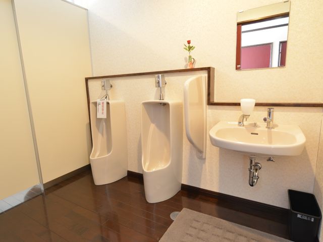 清潔な洗面所とトイレ 共有トイレ 床に滑りにくい素材が使用された洗面とトイレの一角です。利便性と安全に配慮した設計が施されています。