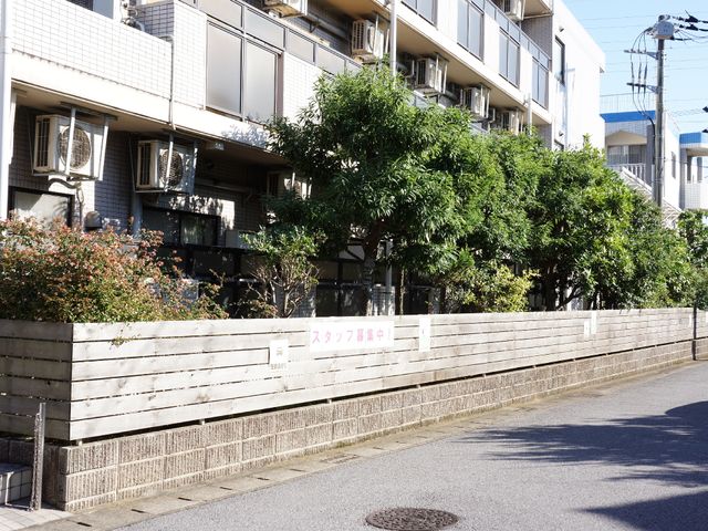 緑あふれる外観 施設外観 静かな街並みに溶け込む、緑豊かな建物前です。清潔感があり、落ち着いた雰囲気の中で働ける環境が提供されています。