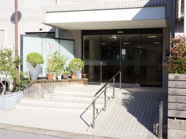 入口と植栽の外観 施設入口 植木鉢に彩られた明るいエントランスが迎えてくれます。階段と手すりが設置され、安全に配慮された設計となっています。