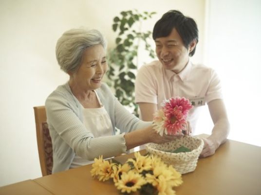 笑顔で花を手渡す様子