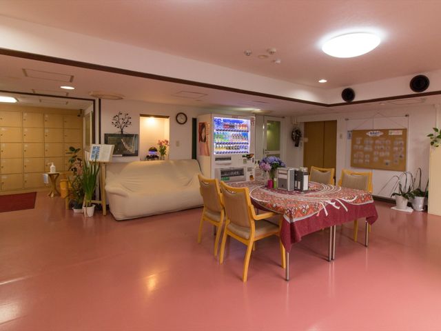 温かみのあるリビング空間 居住ホール 広々とした休憩スペースで、ソファやテーブルが配置されており、心地よい時間を過ごせる場所となっています。