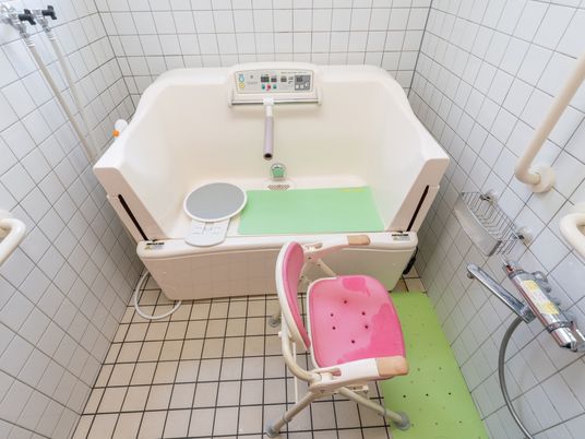 個浴用浴室の一例。介護度の高い入居者様には特殊浴槽が用意されている。介護用椅子が置かれ、壁に手すりが設置されている。