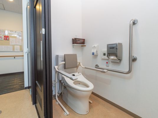 トイレの入り口は引き戸タイプになっている。トイレ内はスペースを広くとっている。便器の両脇に手すりが設置されている。