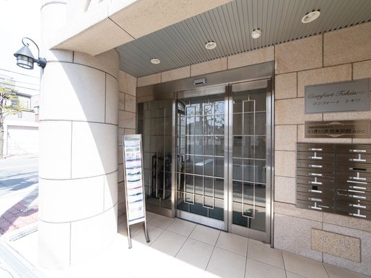 居室への入口近くには各部屋ごとの郵便受けがあり、その上には施設名のプレートが掲示されている。パンフレットも置かれている。