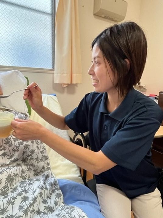 笑顔で食事介助するスタッフ