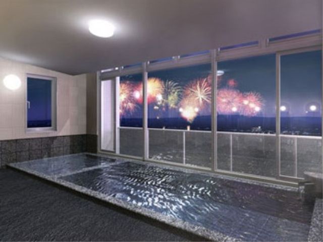 夜景と花火の浴室 展望台浴場 ゆったりとした空間の浴室で、窓の外には美しい夜景と花火が楽しめます。癒しの時間をお過ごしいただける設計です。