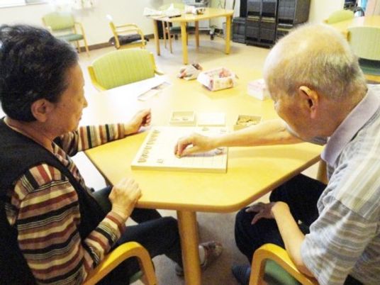 老人がボードゲームを楽しむ様子