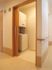 木目調のスライド式のドアの１室に洗濯機と乾燥機を備えている。内部は白を基調とし清潔感に溢れ、気持ちよく洗濯を行える。