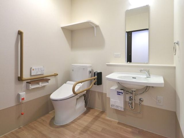 バリアフリーなトイレ 共有トイレ 手すり付きで安全性を考慮した清潔感あるトイレです。利用者の快適さと利便性を重視した設計がなされています。