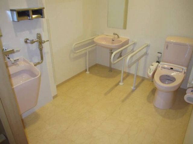 バリアフリー設計の浴室 共有トイレ 手すりが設置された清潔感のあるトイレです。利用者の安全と快適さを考えた設計になっています。