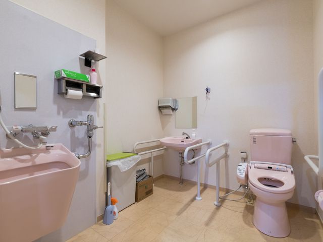 バリアフリーの洗面トイレ 多目的トイレ 手すり付きで安全性を考慮したトイレ空間です。清潔感ある設計が、働く環境の快適さを支えています。