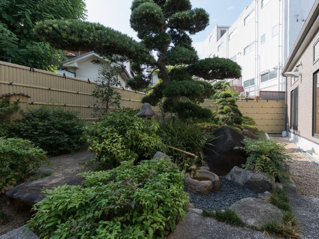 静かな和風庭園風景 日本庭園 緑豊かな中庭は、心安らぐ自然に囲まれた空間を提供し、日々のリラックスタイムに最適です。