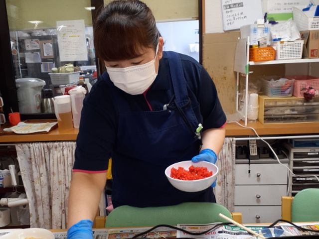 料理を提供するスタッフ キッチン 一生懸命に調理された料理を持つスタッフの笑顔が、穏やかな日常を感じさせてくれます。温かい手作りの食事が、こころを通じてつながりを深めるでしょう。