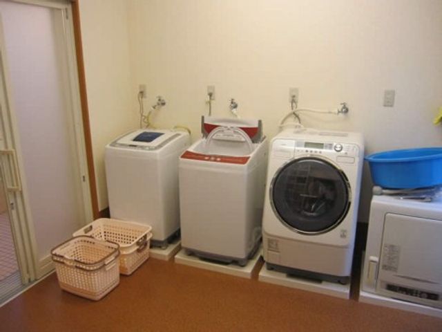 洗濯機と籠のある部屋 ランドリー 自由に利用できる洗濯設備が整った部屋です。清潔感があり、日常生活に必要な洗濯も安心して行えます。
