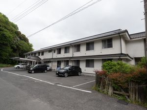 白壁の建物と駐車場施設