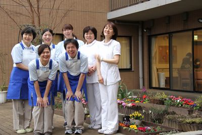 笑顔のスタッフと花壇