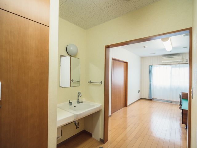 居室入口と洗面台 居室 洗面台が備え付けられた明るい居室です。広々とした空間で、快適な生活を送られることでしょう。