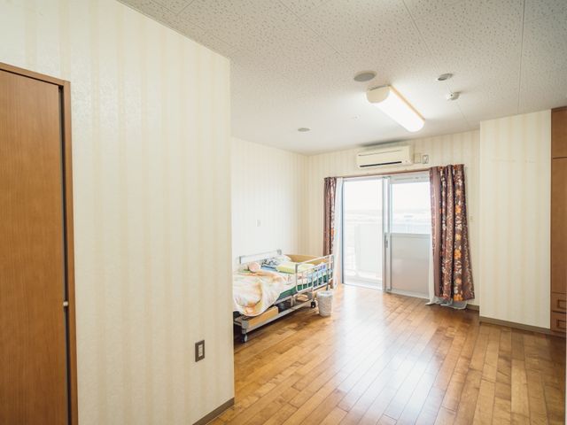 快適な一室の居室 居室 ゆとりのある居室には、窓からの光が差し込み、一人ひとりのくつろぎ時間を引き立てるシーンが広がります。個々のニーズに対応する設備が整っており、快適な生活空間を提供しています。