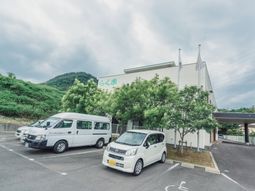 白い建物と駐車場の外観
