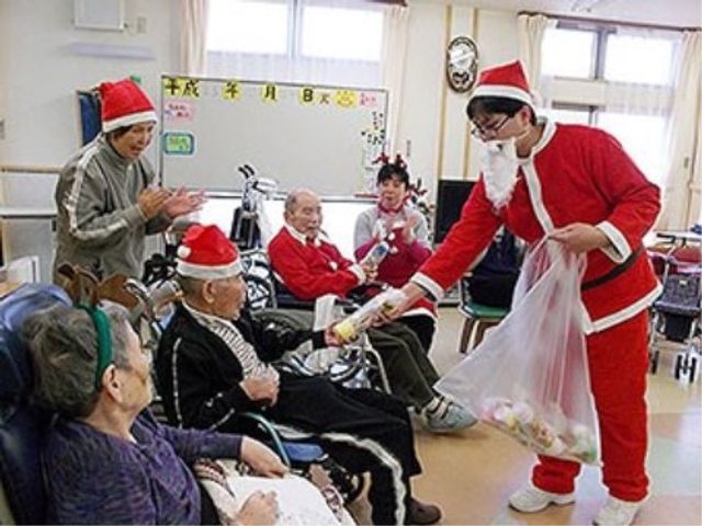 クリスマスイベントの様子 イベント 楽しげなクリスマスイベントを開催しており、利用者の方々が笑顔でプレゼントを受け取り、和やかな雰囲気です。