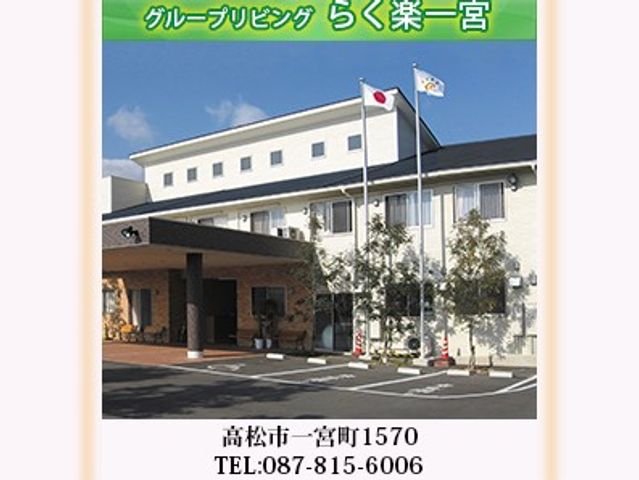 施設の外観 外観   白い建物とひさしのある出入口が見える外観です。前には旗が立ち、来訪時の目印になりそうです。