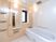 白を基調とした清潔感のある浴室である。転倒防止のための手すりを数か所設置している。また広めの空間を確保している。