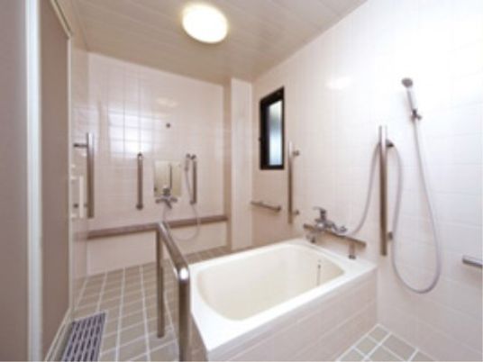 足腰に自信のない入居者様が安心して入浴できるように、各所に手すりを設置している。また明り取りの窓が設置されている。