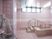 サムネイル 施設の写真 ピンクのタイル調を取入れた浴室はお洒落な印象である。安全に入浴が行えるように、浴槽に階段を設け、手すりを完備している。