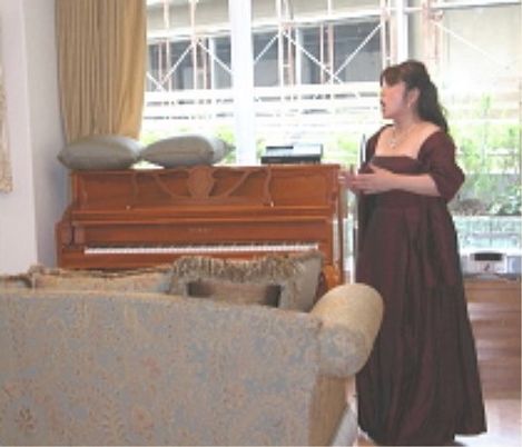 ピアノの前に立つ女性